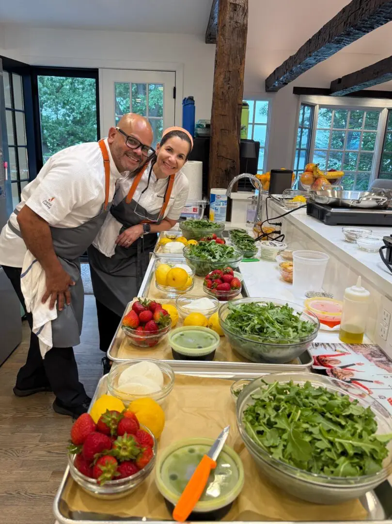 Two chefs preparing fresh ingredients in kitchen.