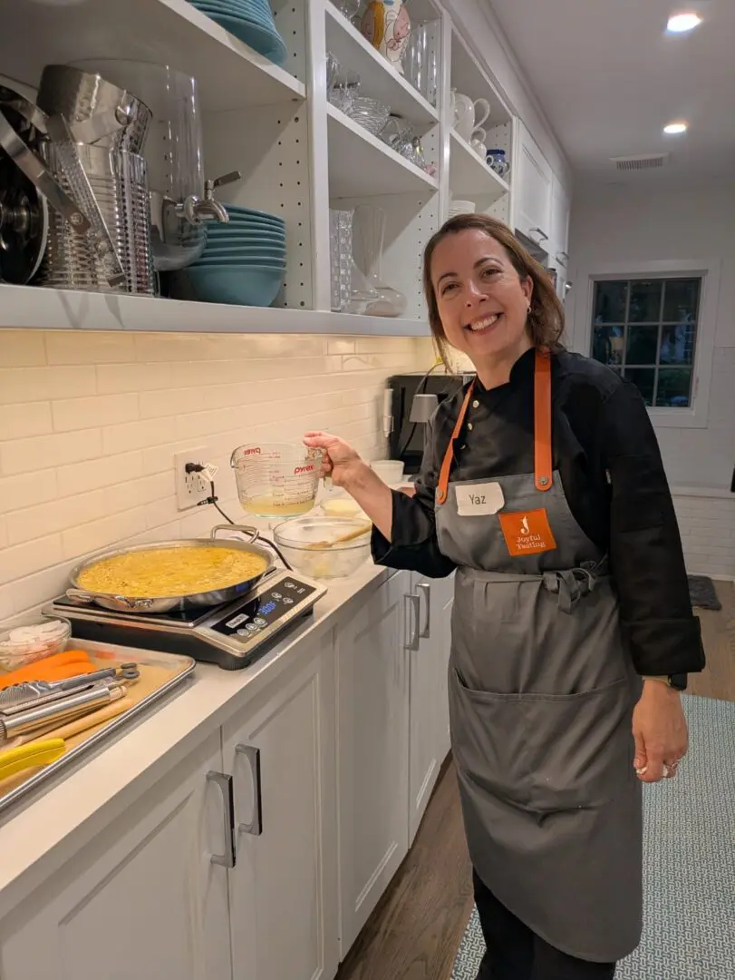 Woman cooking in a kitchen, smiling.