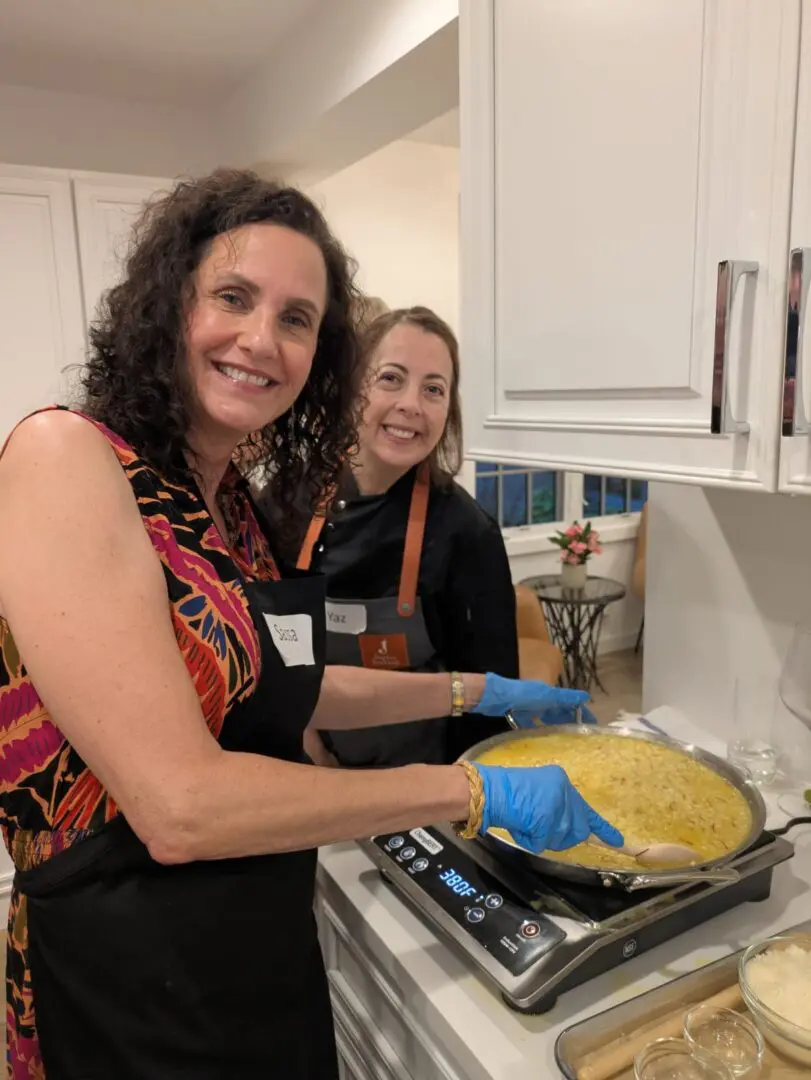 Two women cooking together in kitchen.