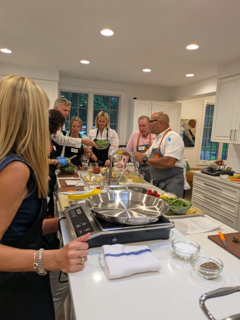 Group cooking class in modern kitchen setting.