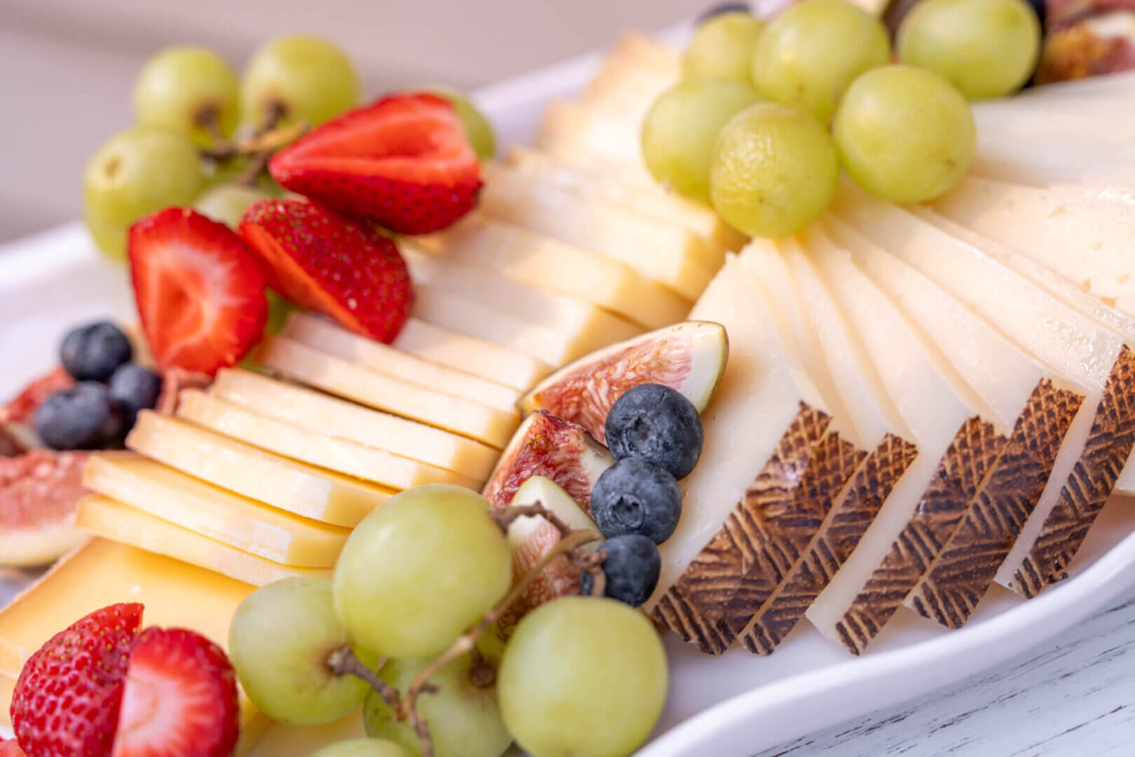 Cheese platter with fruits and berries.